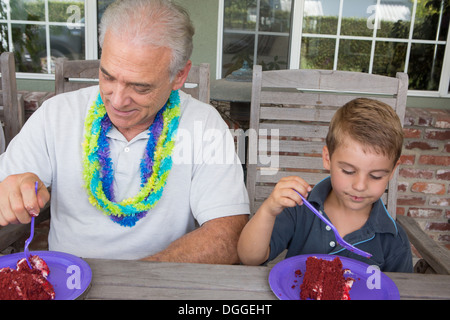 Petit-fils et senior man eating cake Banque D'Images