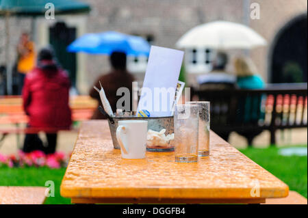 Une table avec des verres vides et une tasse de café sous la pluie, Paffendorf, Rhénanie du Nord-Westphalie Banque D'Images