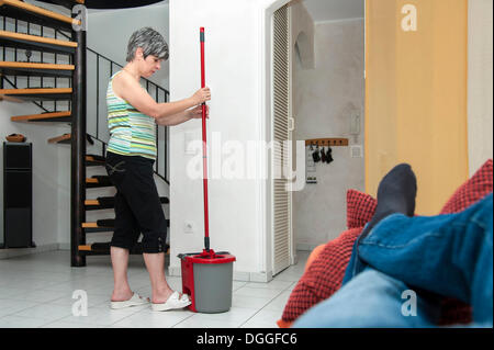 Nettoyage de la femme alors qu'un homme est couché sur la table Banque D'Images