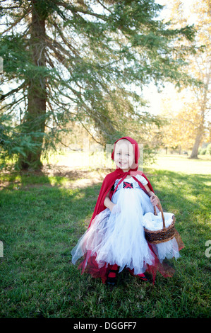 Female toddler in woods habillés en costume chaperon rouge Banque D'Images