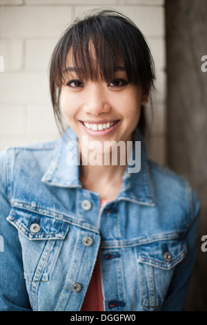 Portrait de jeune fille en face de mur de brique Banque D'Images