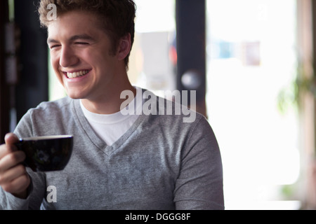 Portrait de jeune homme en cafe holding cup Banque D'Images