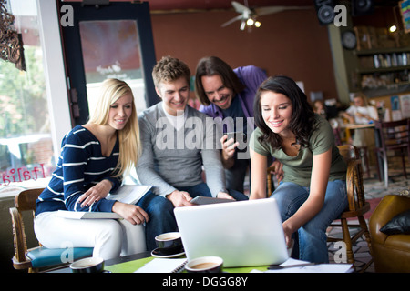 Groupe de personnes réunies autour de l'ordinateur in cafe Banque D'Images