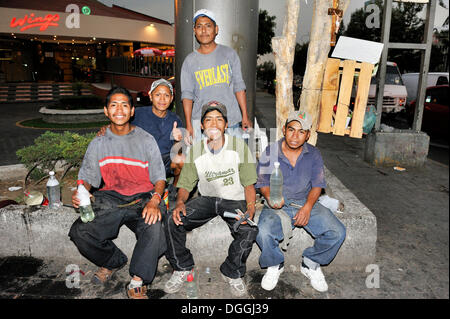 Un groupe de jeunes, les enfants des rues, avec leur équipement pour le nettoyage des vitres de voitures à une intersection, Ciudad de Mexico Banque D'Images