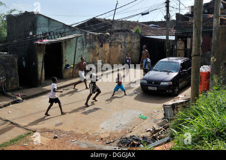 Les jeunes jouent au football dans la rue, quartier de taudis de Favela Morro da Formiga, quartier de Tijuca, Rio de Janeiro, Brésil Banque D'Images