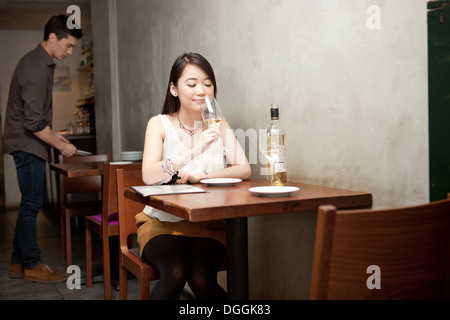 Jeune femme tenant un verre de vin au restaurant Banque D'Images