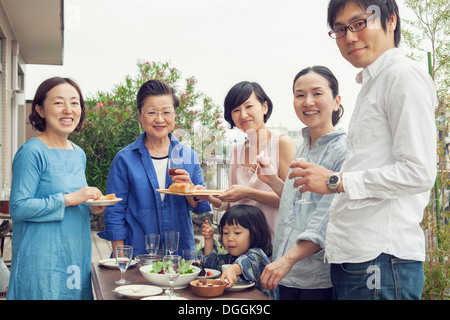 Three generation family eating outdoors, portrait Banque D'Images