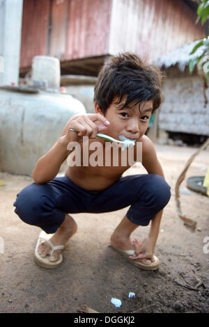 Jeune garçon se brosser les dents à l'extérieur une maison Lompong, commune, district, Province de Takéo Bathi, Cambodge Banque D'Images