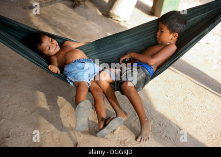 Garçon et fille couché dans un hamac, Trapang Village, district, Province de Takéo Bathi, Cambodge Banque D'Images