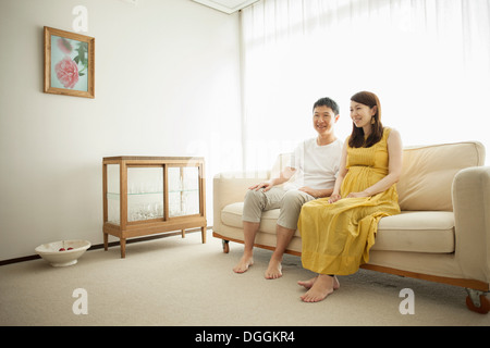 Pregnant woman sitting on sofa Banque D'Images