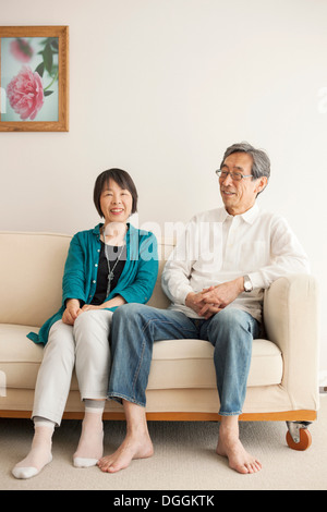 Senior couple sitting on sofa, portrait Banque D'Images