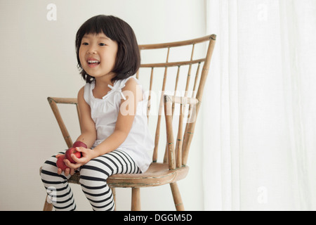 Girl sitting on wooden chair, portrait Banque D'Images