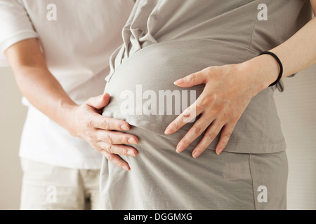 L'homme de toucher le ventre de femme enceinte, cropped portrait Banque D'Images