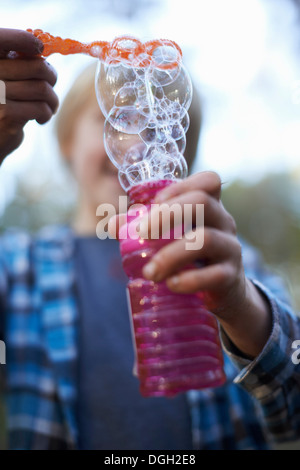 Boy holding bouteille de bulles Banque D'Images