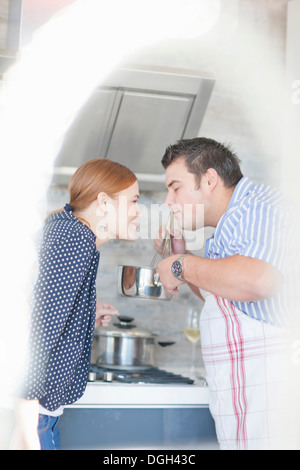 Jeune couple qui sent l'arôme de la casserole de cuisson Banque D'Images