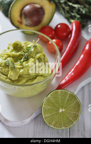 Guacamole sauce dans un bol en verre sur fond de bois Banque D'Images
