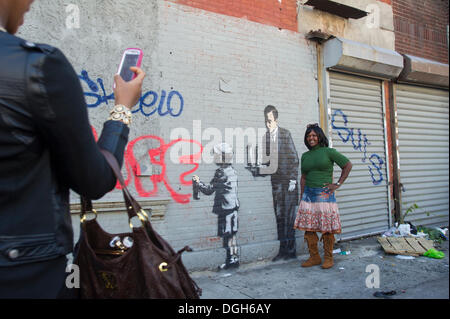 New York, USA. 21 Oct, 2013. Les amateurs de street art affluent au quartier Melrose du Bronx à New York le lundi 21 octobre, 2013 pour voir le vingt et unième tranche de l'art graffiti de Banksy, l'insaisissable artiste de rue, c'est la création d'œuvres autour de la ville chaque jour pendant le mois d'octobre. Credit : Frances M. Roberts/Alamy Live News Banque D'Images