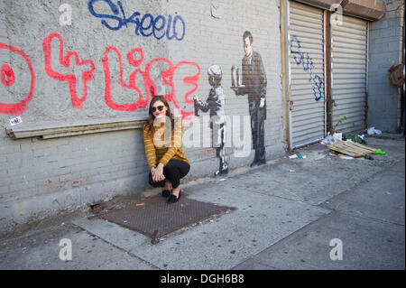 New York, USA. 21 Oct, 2013. Les amateurs de street art affluent au quartier Melrose du Bronx à New York le lundi 21 octobre, 2013 pour voir le vingt et unième tranche de l'art graffiti de Banksy, l'insaisissable artiste de rue, c'est la création d'œuvres autour de la ville chaque jour pendant le mois d'octobre. Credit : Frances M. Roberts/Alamy Live News Banque D'Images