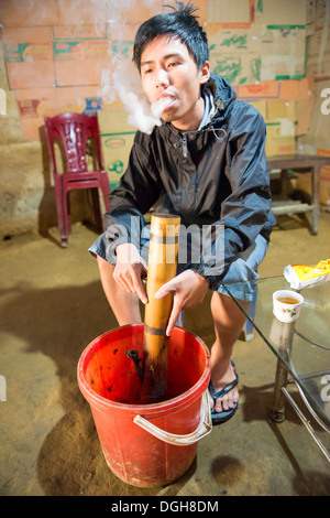 Groupe de la minorité Hmong fleurs man smoking avec pipe du bambou, Bac Ha, Lao Cai, Vietnam Banque D'Images