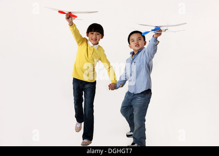 East Asian boy and girl Playing with model airplanes main dans la main Banque D'Images