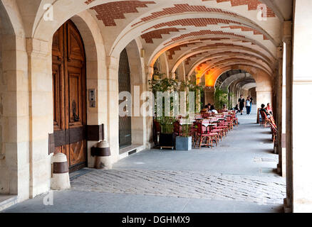 Arcade avec un restaurant terrasse sur la Place des Vosges, quartier du Marais, Paris, Ile de France, France, Europe Banque D'Images