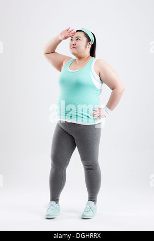 Une grosse fille debout dans une salle de sport outfit Banque D'Images