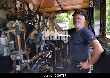 Bernd Roschach conducteur de train, président de l'Acher Valley Railway Society, debout dans une locomotive de chemin de fer de la vallée de l'Acher Banque D'Images