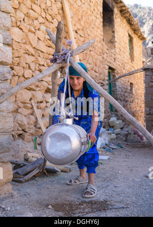 Woman Shaking lait dans l'ancien village kurde de Palangan au crépuscule, l'Iran Banque D'Images