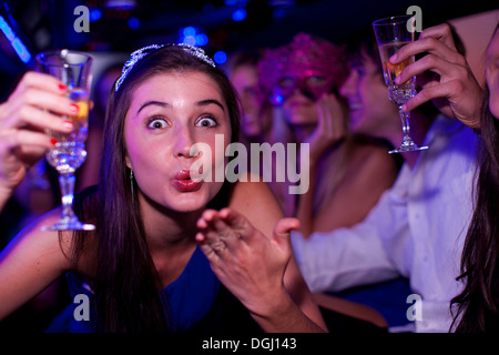 Young woman blowing kiss in limousine Banque D'Images