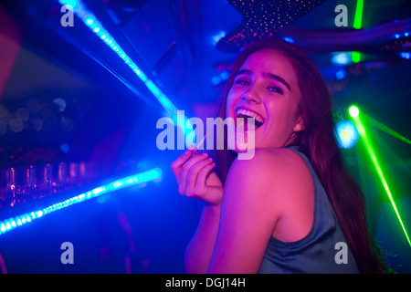 Young woman laughing at bar in nightclub Banque D'Images