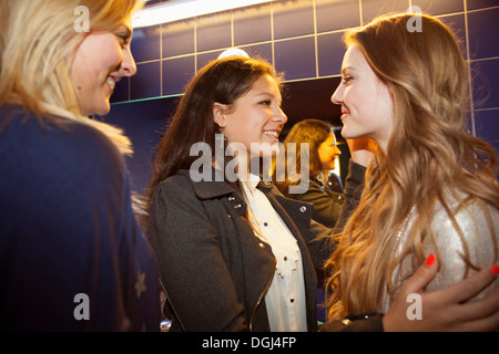 Trois adolescentes chat et les toilettes en souriant Banque D'Images