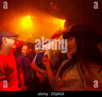 Groupe de personnes au parti, man kissing woman's neck Banque D'Images