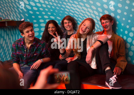 Teenage boy taking photo de groupe d'amis using smartphone Banque D'Images