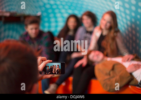 Teenage boy taking photo de groupe d'amis using smartphone Banque D'Images