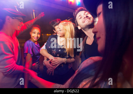 Groupe de personnes au parti, man kissing woman's neck Banque D'Images