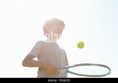 Garçon balle rebondissante sur raquette de tennis Banque D'Images