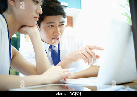 Un homme et une femme travaillant avec des ordinateurs portables Banque D'Images