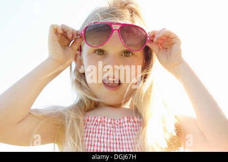 Mettre l'enfant sur les lunettes de soleil sur jour ensoleillé chaud Banque D'Images
