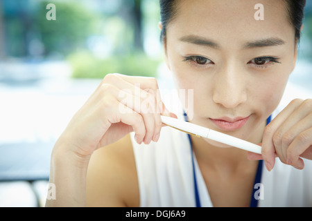 La pensée d'une femme avec un stylo dans sa main Banque D'Images