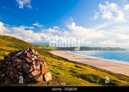 Soir lumière tombe sur le cairn au sommet de la colline surplombant Putsborough Sands Potiers et Baggy Point. Banque D'Images