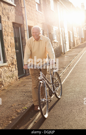 Man en poussant son vélo sur street Banque D'Images