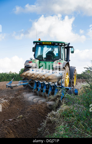 Le labour avec un tracteur John Deere et charrue réversible à North Norfolk. Banque D'Images