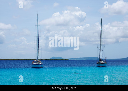 Yachts amarrés dans le port de Kralendijk avec les collines de Washington Slagbaai National Park dans l'arrière-plan. Banque D'Images