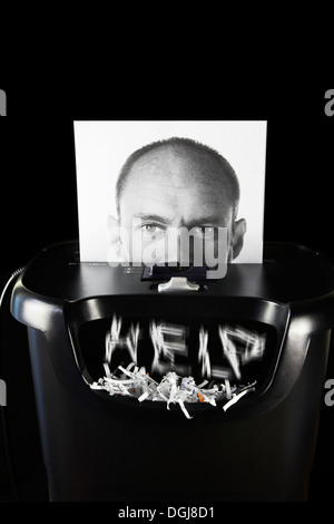 Photographie d'un visage de l'homme traversant une déchiqueteuse. Banque D'Images