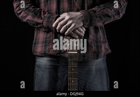 Un homme tenant une guitare acoustique. Banque D'Images