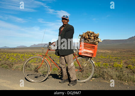 L'homme Local avec un vélo et une boîte de bois de chauffage sur le porte-bagages, près de Calvinia, Northern Cape Province, South Africa, Africa Banque D'Images