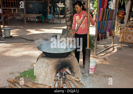 Femme khmère palm en remuant sap en un métal chauffé traditionnel chaudière pour produire le sucre de palme, Siem Reap, Cambodge, en Asie du sud-est Banque D'Images