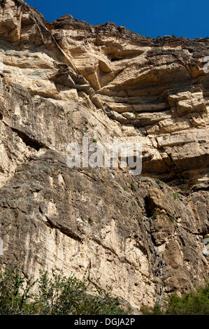 Rock face au flanc ouest du Grand Canyon d'Oman dans le Wadi à Nakhar avec randonneurs sur le parcours menant à la ligne fixe Banque D'Images