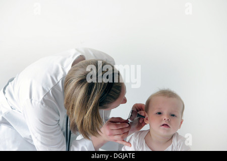 Femme médecin examinant l'oreille de bébé Banque D'Images