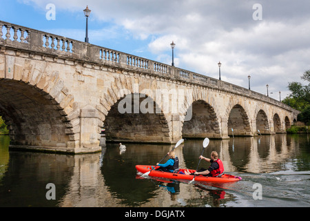 Couple canoë le long de la rivière Thames en vertu de Maidenhead, Berkshire, Angleterre Pont, FR, UK. Banque D'Images